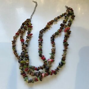 This is a necklace with 3 strands of “stones.”  Multicolored.